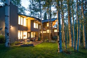 a house in the middle of a yard with trees at Elegant Lodge with Hot Tub Walk to Highland Lifts in Aspen