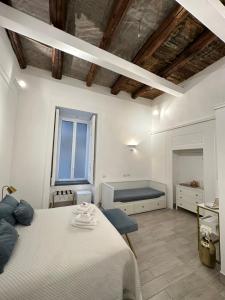 biała sypialnia z łóżkiem i oknem w obiekcie MAISON MARINELLA w mieście Napoli