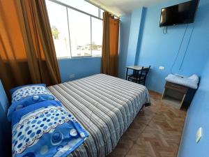 Habitación pequeña con cama y ventana en Hostal EL TAMBO en Ica