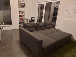 a gray couch in a living room with a window at Appartement entier in Rennes