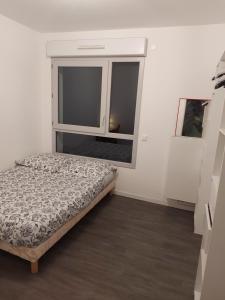 um quarto com uma cama e uma janela em Appartement entier em Rennes