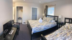 a bedroom with two beds and a table and chairs at Cambie Lodge in Vancouver