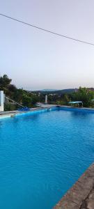 a large blue swimming pool with the ocean in the background at Casa do Monte in Castro Daire