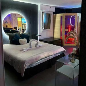 - une chambre avec un grand lit et une table en verre dans l'établissement Suite & Spa Jacuzzi, sauna, lit king size,Netflix, à Montigny-le-Bretonneux
