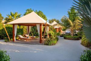 um gazebo com um banco e uma mesa em The Ritz-Carlton Ras Al Khaimah, Al Hamra Beach em Ras al-Khaimah