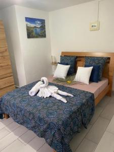 a bedroom with a bed with two swans on it at LES GÎTES DE BIBINE gîtes tout confort coin calme et tranquille in Rabi