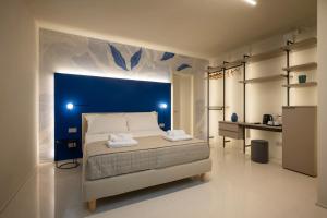 锡罗洛Marna Relais的卧室里有一张大床,墙壁是蓝色的