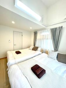 two beds in a hotel room with a bag on them at 江戸川橋レジデンス EDOGAWABASHI RESIDENCE in Tokyo