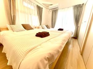 two large beds in a room with a large window at 江戸川橋レジデンス EDOGAWABASHI RESIDENCE in Tokyo