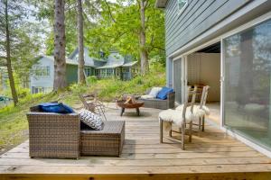 een veranda met rieten stoelen op een houten terras bij Modern Mountainside Home with Trail Access On-Site in Boiceville