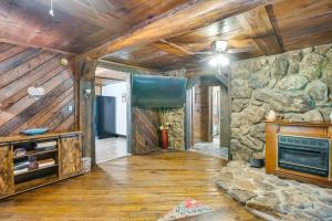 a living room with a stone wall and a fireplace at French Lick Getaway with Deck, Grill and Fire Pit! in French Lick