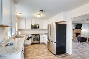 a kitchen with white cabinets and a stainless steel refrigerator at Quiet Ridgecrest Vacation Rental with Private Yard! in Ridgecrest