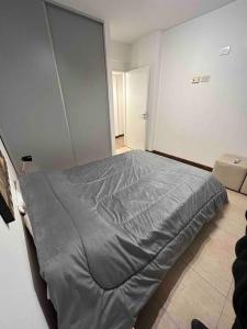 1 dormitorio con 1 cama con manta gris en Departamento a estrenar en Buenos Aires