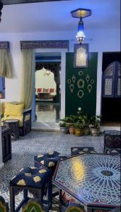 a living room with a couch and a table and chairs at Hôtel Al Kalaa in Chefchaouen