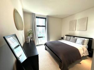 a bedroom with a large bed and a window at Entire 1 bed Apartment with private Balcony in London