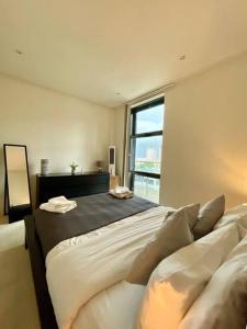 a bedroom with a large bed and a window at Entire 1 bed Apartment with private Balcony in London