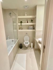 a white bathroom with a toilet and a sink at Entire 1 bed Apartment with private Balcony in London