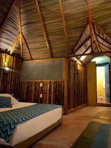 ein Schlafzimmer mit einem Bett in einem Zimmer mit Holzwänden in der Unterkunft Mangoo Glamping in Melgar