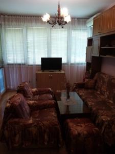 salon z kanapą i stołem w obiekcie Апартамент Панорамна гледка w mieście Trjawna
