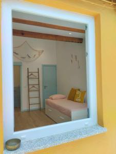 ein Spiegel, der ein Schlafzimmer mit einem Bett und einer Leiter reflektiert in der Unterkunft Maria Sardinha_As Três Marias in Matosinhos