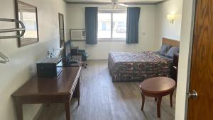 a small hotel room with a bed and a desk at Countryside Inn Motel Albert Lea in Albert Lea