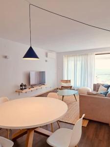 a living room with a table and a couch at Sesimbra Califórnia beach front in Sesimbra