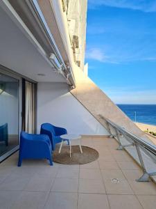 a balcony with two chairs and a table and the ocean at Sesimbra Califórnia beach front in Sesimbra