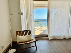 um quarto com uma cadeira e vista para o oceano em Sesimbra Califórnia beach front em Sesimbra