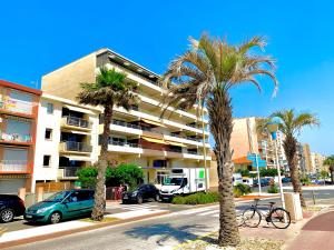 a parking lot with palm trees in front of a building at LE PALAIS dETE T4 6-8 115m2 grand standing garage carplug in Canet-en-Roussillon