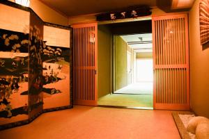 een hal met een open deur met een spiegel bij Tanakaya in Kurobe