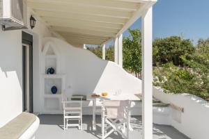 a white porch with a table and chairs on it at Studios Farma in Agia Anna Naxos