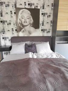 una camera con un grande letto con un poster di una donna di Hollywood Dream 