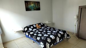 1 dormitorio con 1 cama con edredón blanco y negro en Hermoso departamento amoblado! en Mendoza