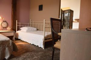 sypialnia z łóżkiem, krzesłem i zegarem w obiekcie MARGOT'L w mieście Rochefort