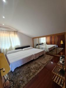 Un dormitorio con una cama grande y un espejo. en StarHome, en San Miguel de Meruelo