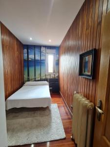 Un dormitorio con una cama en una pared de madera. en StarHome, en San Miguel de Meruelo