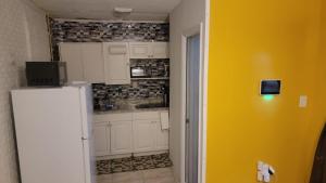 a kitchen with white cabinets and a yellow wall at Sunrise Efficiency in Sunrise +12 photos