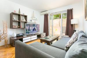 - un salon avec un canapé et une télévision dans l'établissement Apartments with WiFi Makarska - 20217, à Makarska