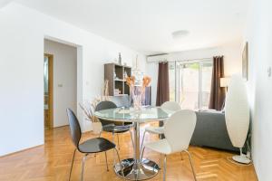 une salle à manger avec une table et des chaises en verre dans l'établissement Apartments with WiFi Makarska - 20217, à Makarska
