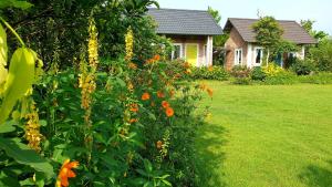 um arbusto com flores de laranja em frente a uma casa em Fefe garden em Ba Vì