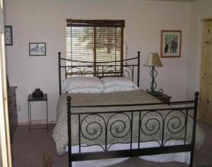 1 dormitorio con cama negra y ventana en Tunk Valley Ranch House, en Riverside