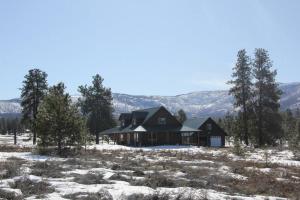 una casa en un campo nevado con montañas en el fondo en Tunk Valley Ranch House, en Riverside