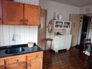 uma cozinha com um lavatório e uma bancada em Casa da vovó em Gramado