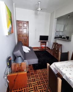 a living room with a table and a kitchen at Ap Na Barra, Frente Do Farol in Salvador