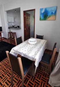 a dining room with a table and chairs and a kitchen at Ap Na Barra, Frente Do Farol in Salvador