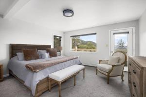 a white bedroom with a large bed and a chair at Beautiful View Point Villa in Conifer