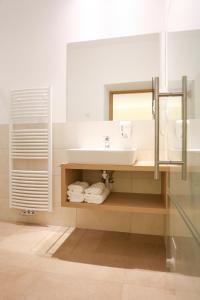een badkamer met een wastafel, een spiegel en handdoeken bij Hotel Ansitz Gamp in Chiusa