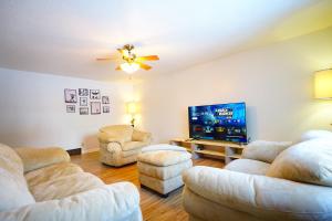 a living room with two couches and a flat screen tv at Blue House 2 in Sioux Falls