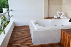 La salle de bains est pourvue d'une baignoire et de parquet. dans l'établissement Brisa Color Esmeralda, à Brisas de Zicatela