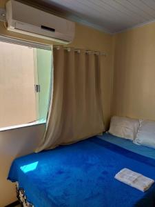 a bedroom with a blue bed with a window at Lençóis Ville residence - Chalé 38 in Barreirinhas +36 photos